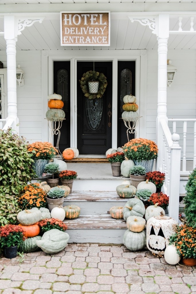A cute farmhouse style porch with Halloween decorations and pumpkins. 