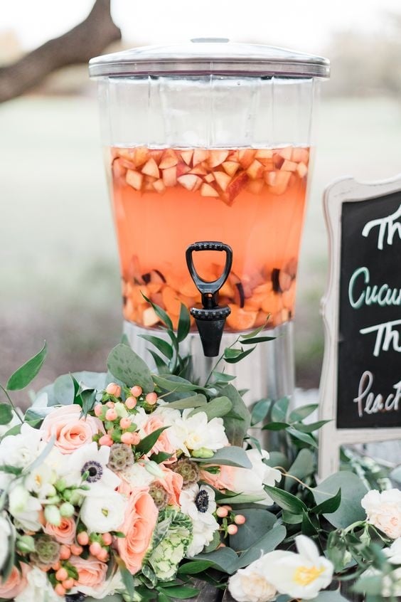 A peach wedding drink in a dispenser. 