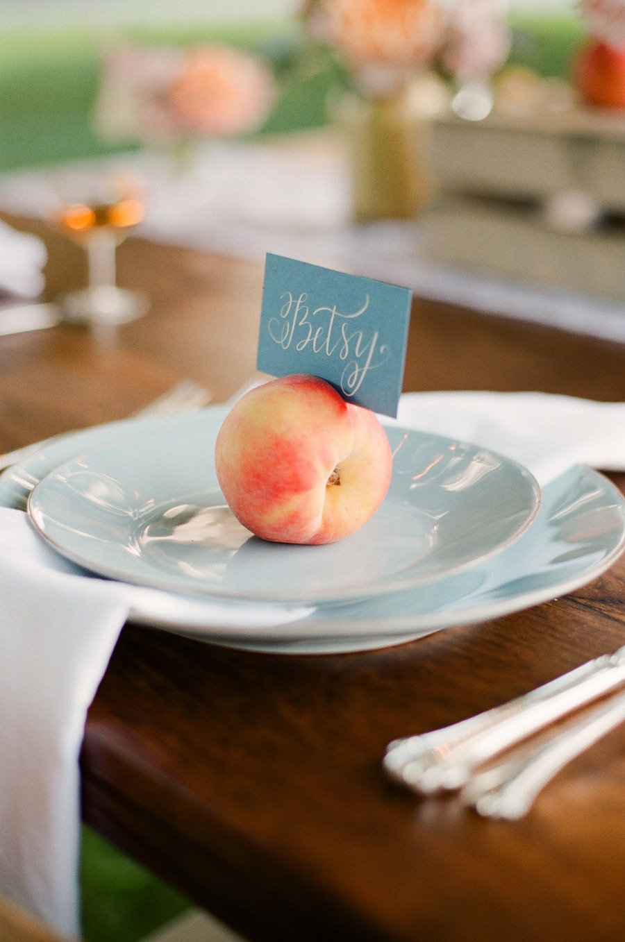 A peach place card on a blue plate. 