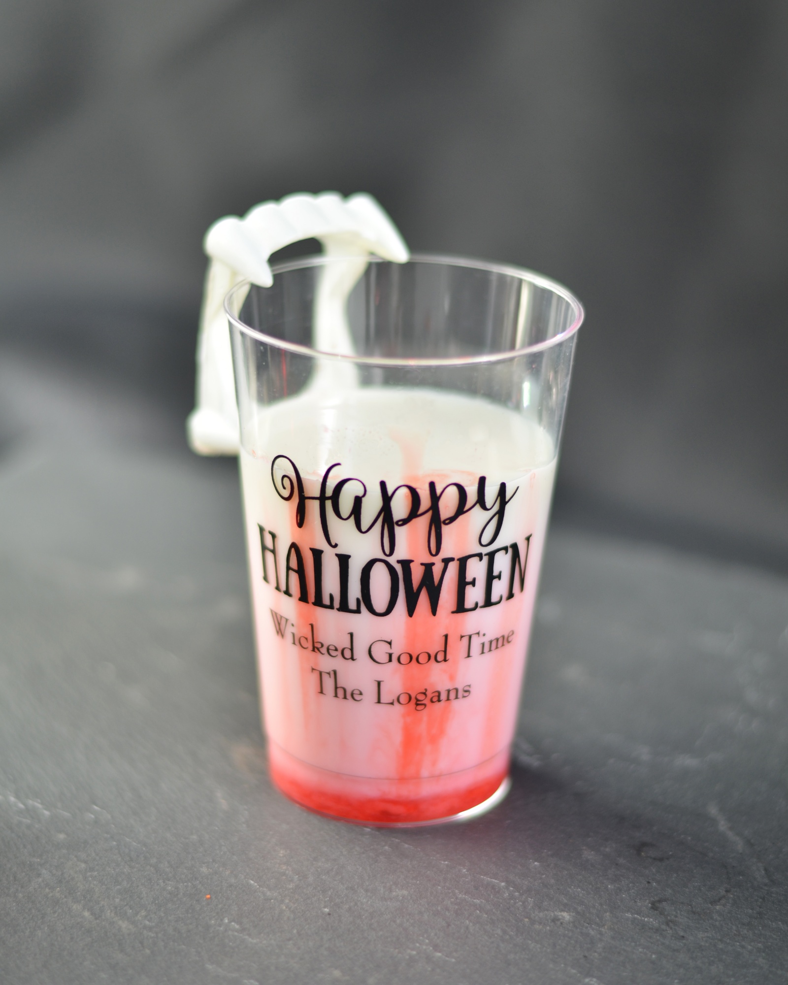 Kids Halloween drink with milk and strawberry syrup called vampires bite in a personalized Halloween cup. 