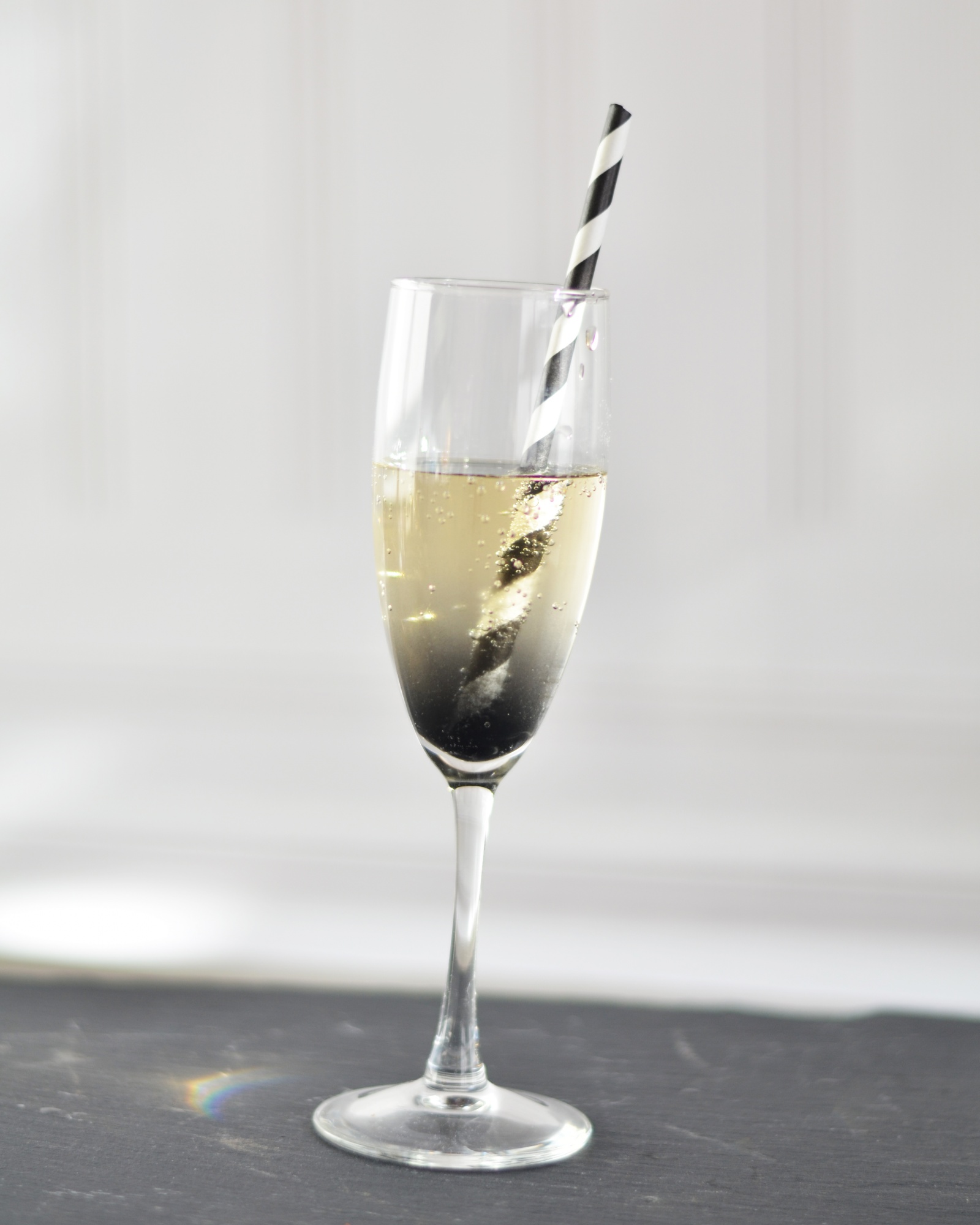 Black charcoal prosecco as a Halloween cocktail in a champagne glass.